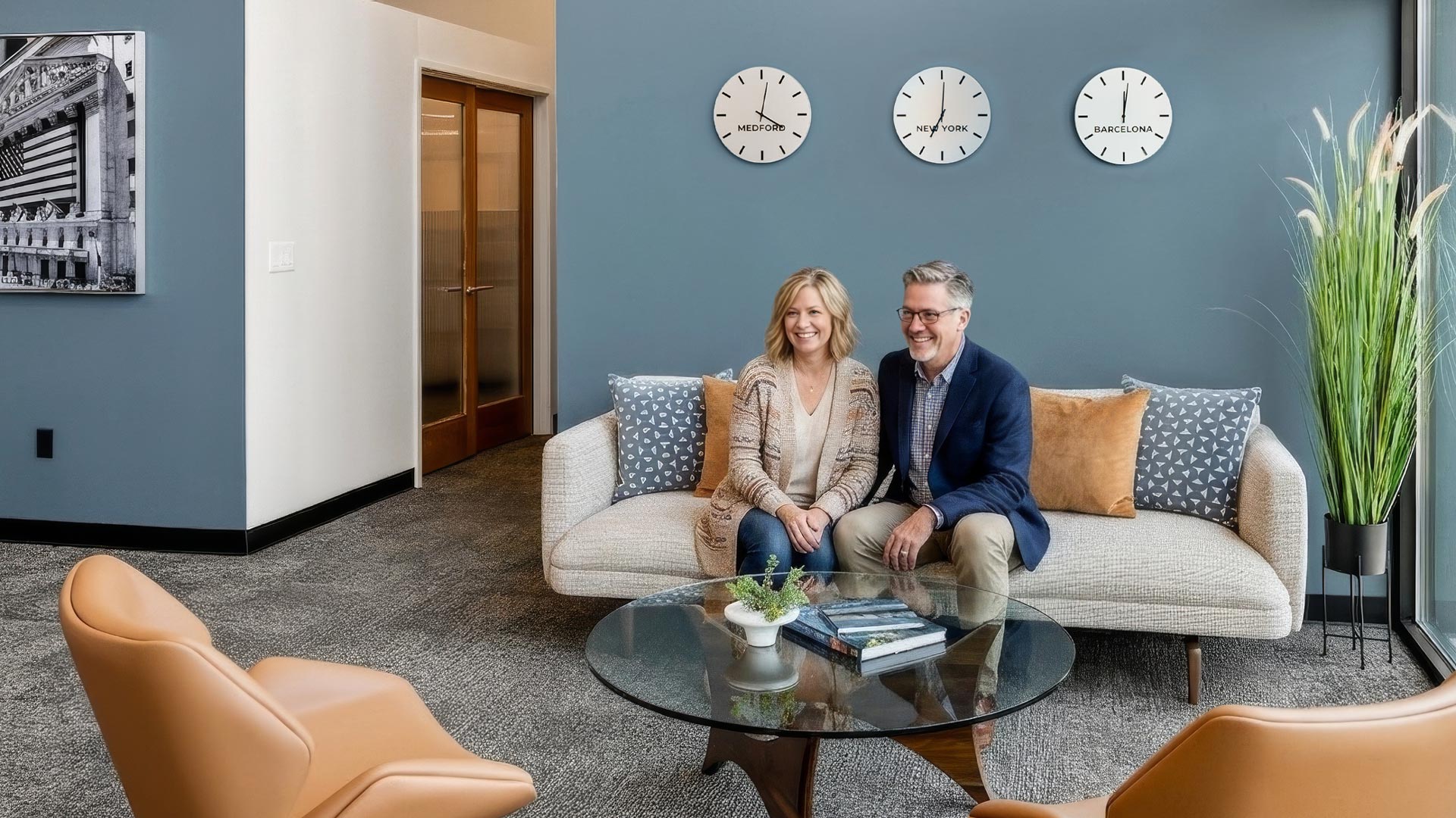 smiling couple sitting on couch in lobby of Medford retirement investment advisor office